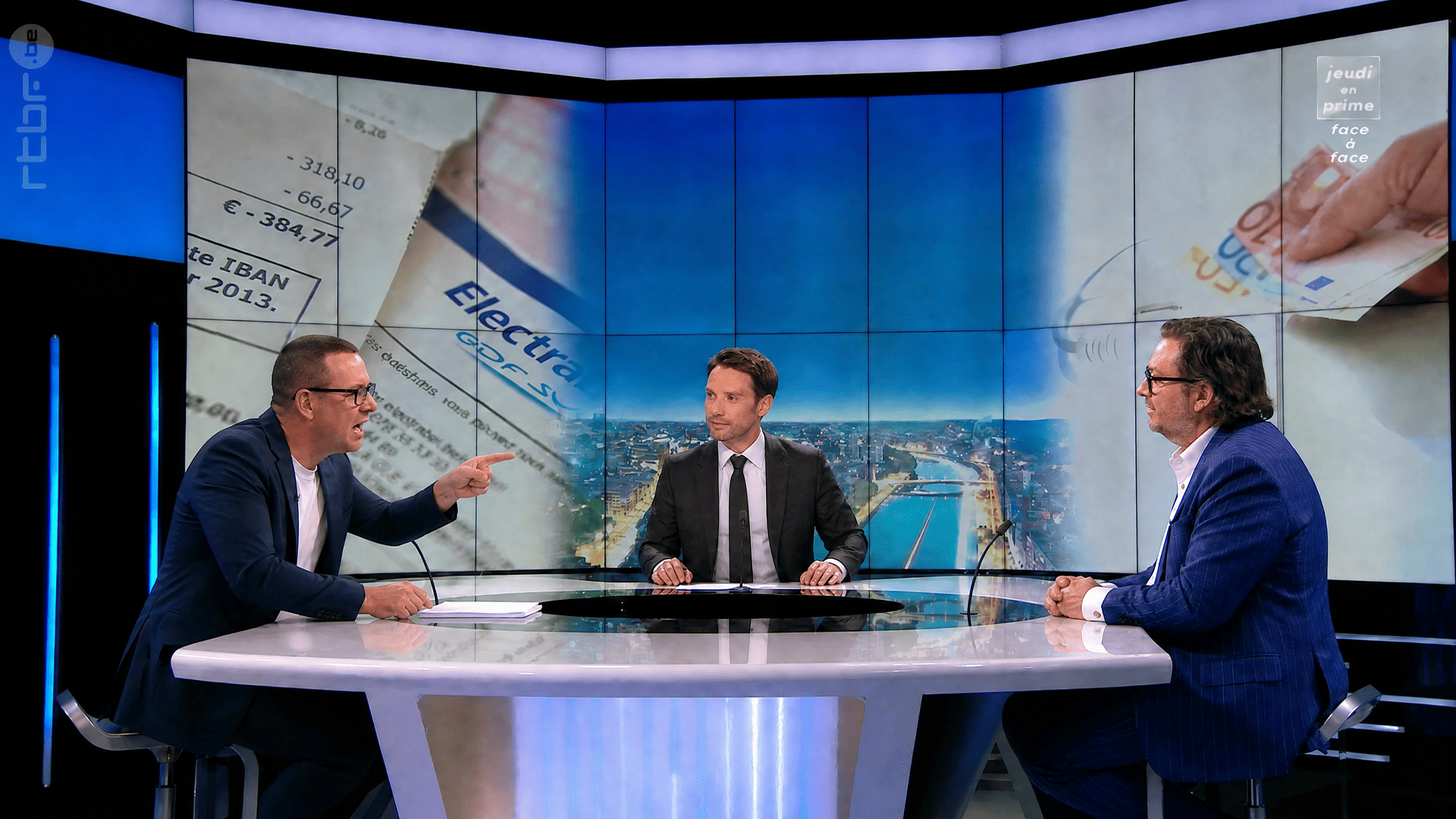 Raoul Hedebouw sort les documents pendant que Marc Coucke se raidit